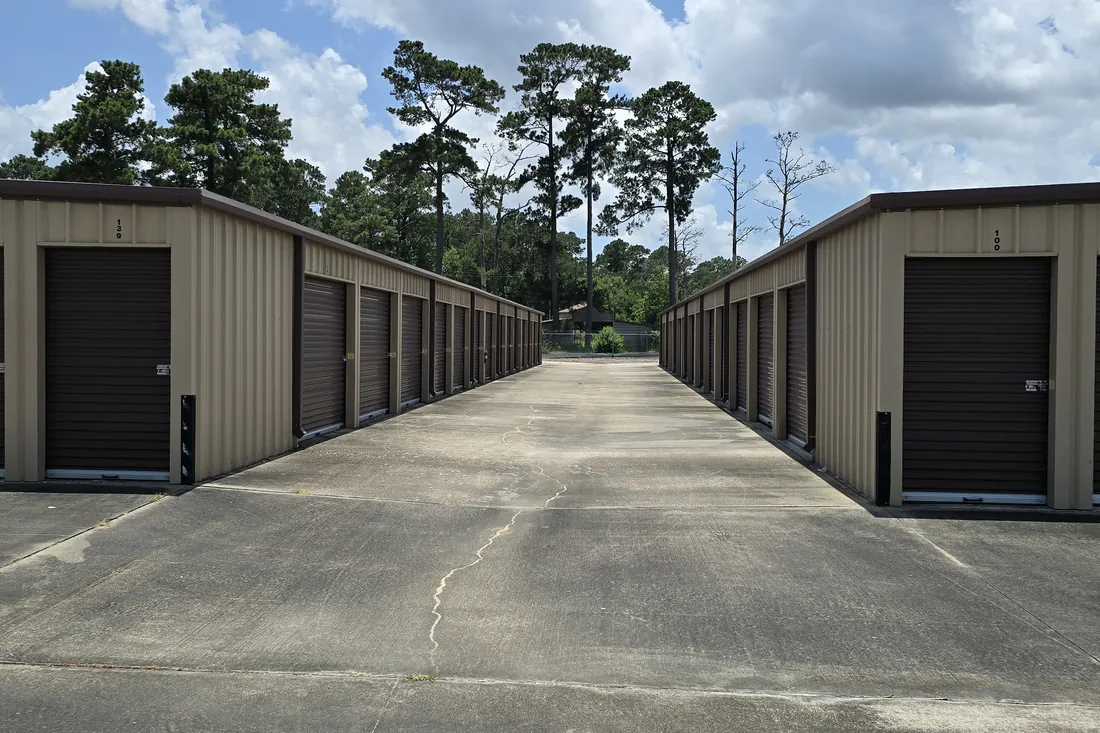 Wide drive aisle between rows of drive-up storage units at AAA Vault Storage in Orange, TX